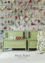 Furniture painted in Gatineau Milk Paint by Homestead House against wood walls with flowers.