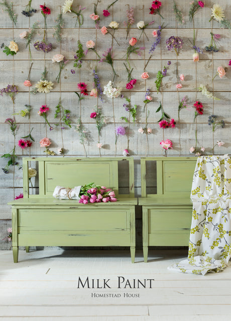Furniture painted in Gatineau Milk Paint by Homestead House against wood walls with flowers.