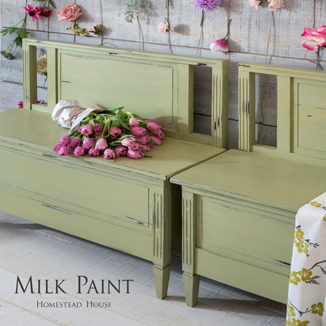 Pink tulips on a bench painted with Gatineau Milk Paint by Homestead House, next to hanging flowers.