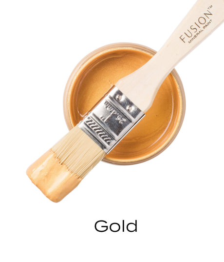 Fusion Mineral Paint Gold Metallic brush resting on open jar, top-down view with gold paint visible below.