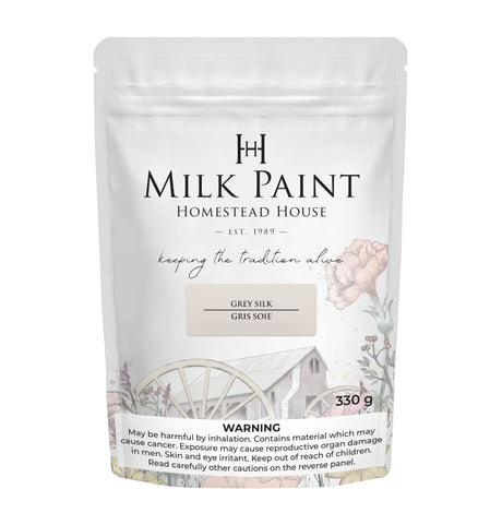 330g Homestead House Grey Silk Milk Paint bag with floral and wagon wheel art, warning text below.