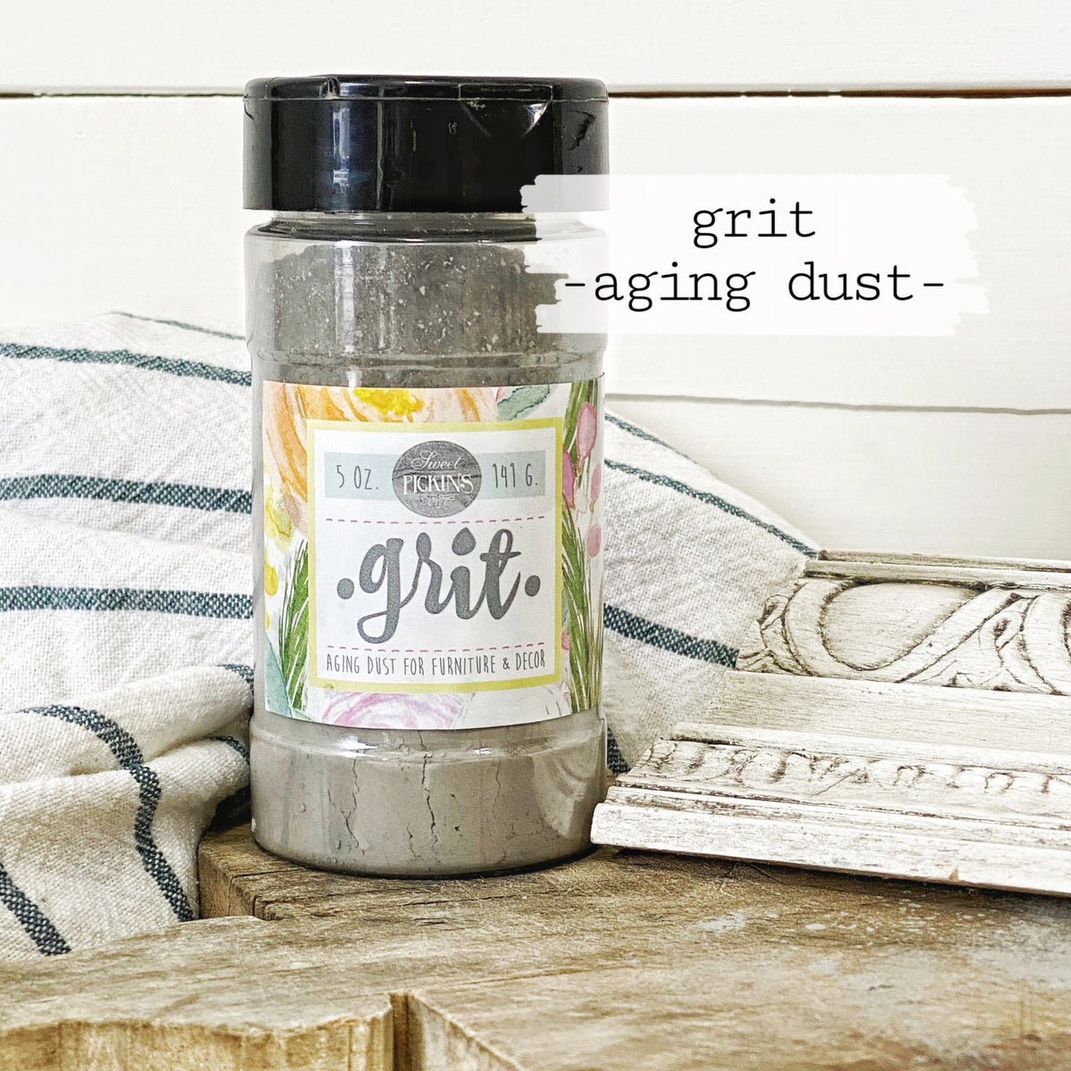 Old Fashioned Milk Paint Grit Aging Dust by Sweet Pickins displayed on a striped surface.