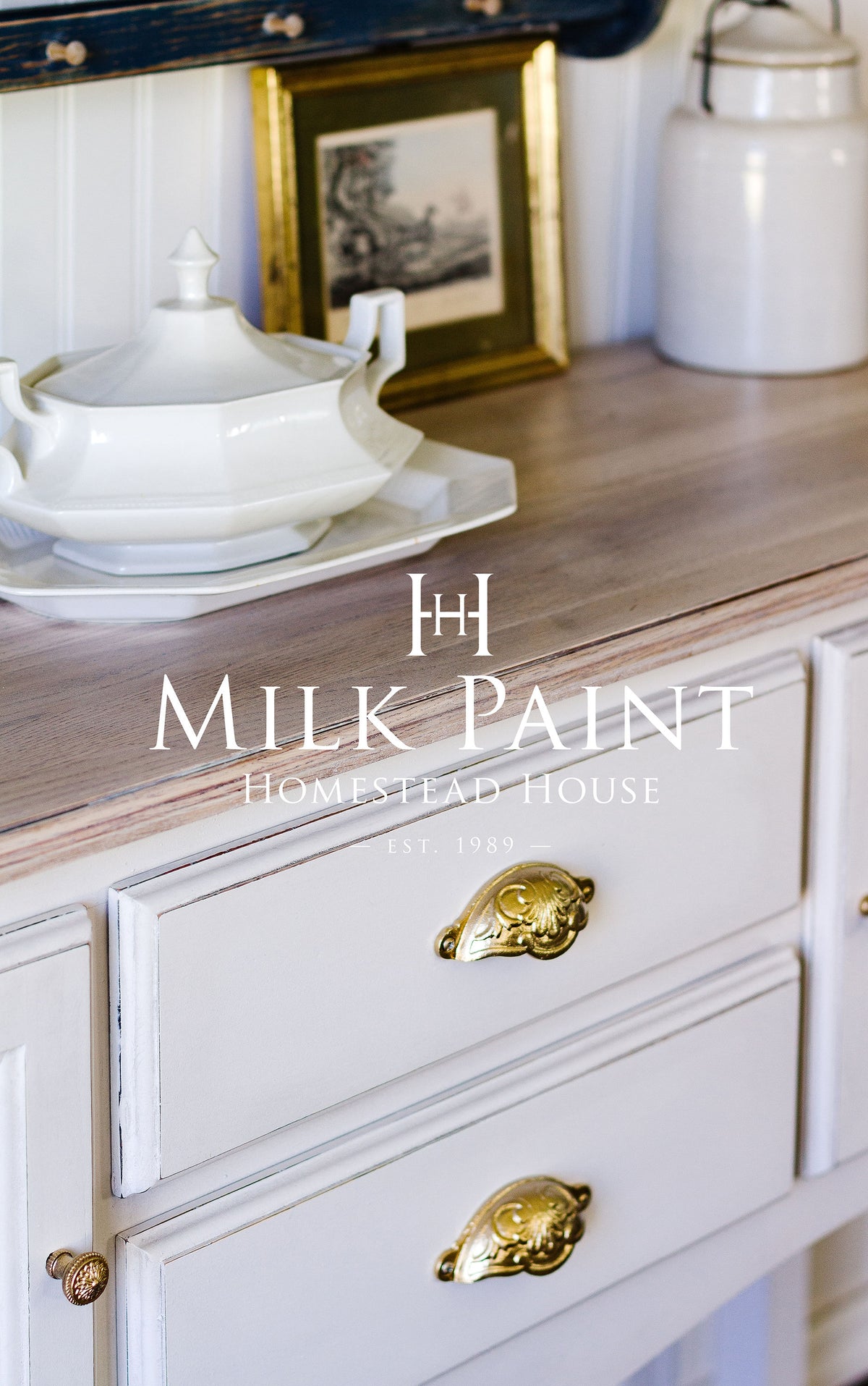 White cabinet with gold handles, white dishes, and artwork; text: Gustavian White Milk Paint by Homestead House.