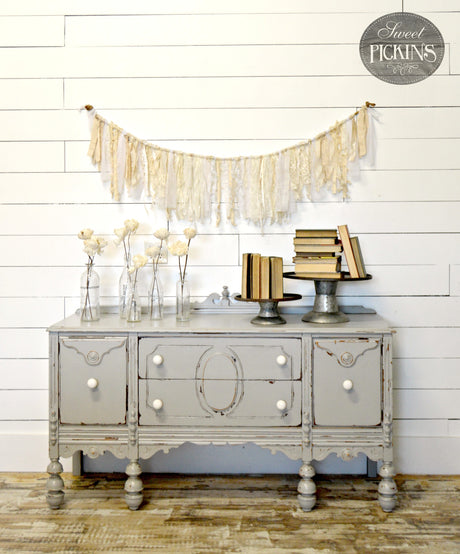 Gray vintage sideboard in Sweet Pickins Milk Paint by Old Fashioned Milk Paint with vases, flowers, and books on top.