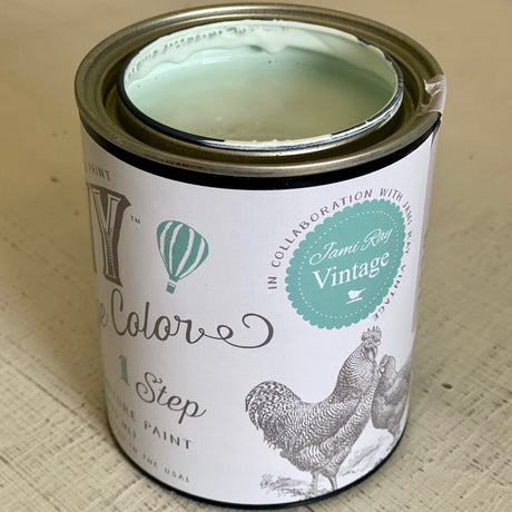 Open can of Haint Blue DIY Cottage Color by DIY Paint Co. on a light wood surface.