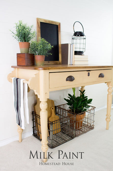 Wooden table with decor and plants against a wall painted in Hampton Milk Paint by Homestead House.