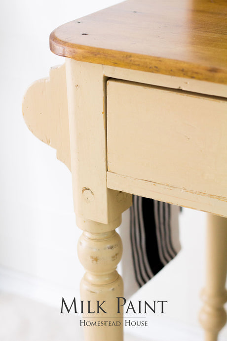 Cream table with brown top, painted in Hampton Milk Paint by Homestead House; branding is visible.