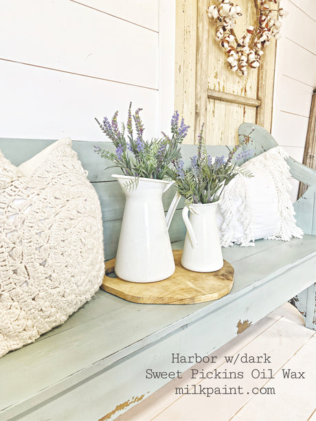 Two white pitchers with lavender sprigs on a tray, set on a Harbor-painted bench by Old Fashioned Milk Paint.