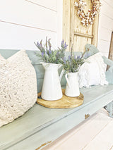Two white pitchers with lavender on a bench painted in Harbor by Old Fashioned Milk Paint, tray and rustic door behind.