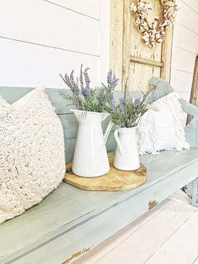 Two white pitchers with lavender on a bench painted in Harbor by Old Fashioned Milk Paint, tray and rustic door behind.