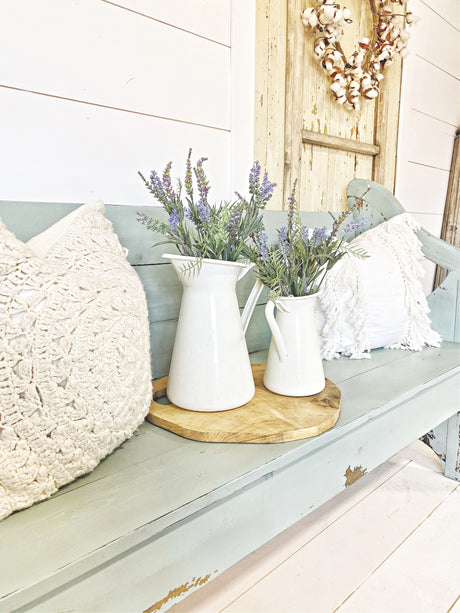 Two white pitchers with lavender on a bench painted in Harbor by Old Fashioned Milk Paint, tray and rustic door behind.