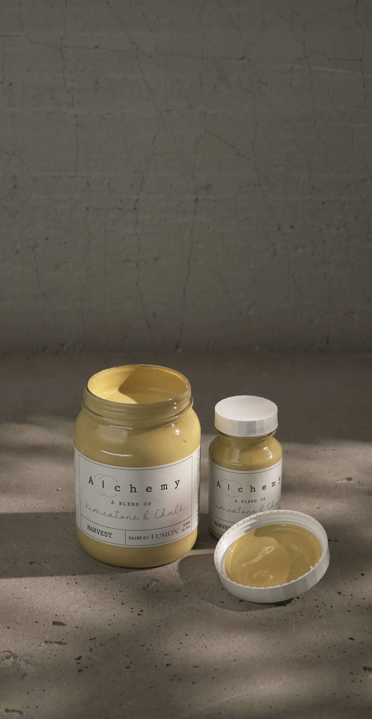 Three jars of Fusion Mineral Paint Harvest Alchemy; one jar is open showing yellow chalk paint.