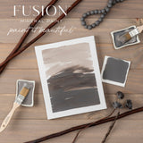 Hazelwood Fusion Mineral Paint swatches with brushes, trays, and decor displayed on a wooden surface.