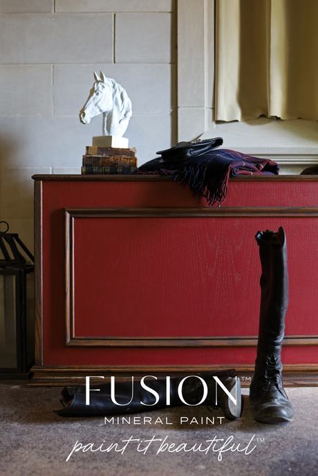 Red cabinet painted in Fusion Mineral Paint’s Highlander, with a horse head statue, folded clothes, and boots in front.