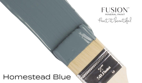 Paintbrush with Homestead Blue Fusion Mineral Paint by Fusion Mineral Paint on a plain white background.
