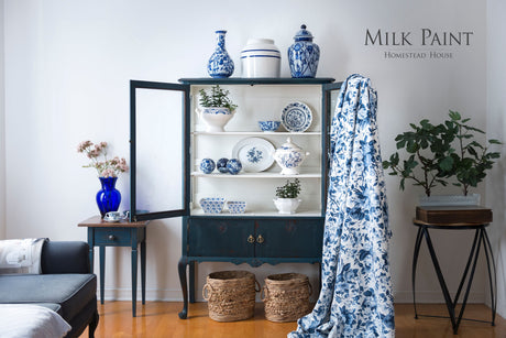 Homestead Blue Milk Paint dark blue cabinet by Homestead House, with ceramics, textiles, and plants displayed on top.