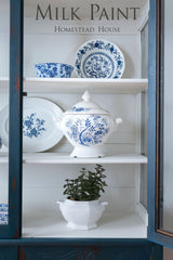 Blue and white dishes with a lidded tureen painted in Homestead Blue Milk Paint by Homestead House on shelves.