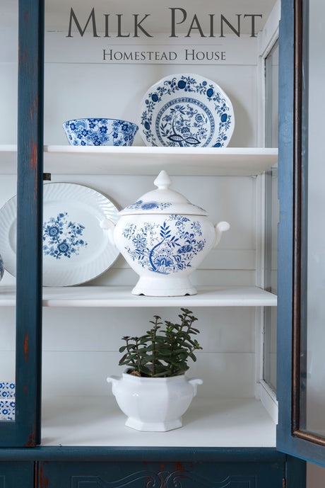 Blue and white dishes with a lidded tureen painted in Homestead Blue Milk Paint by Homestead House on shelves.