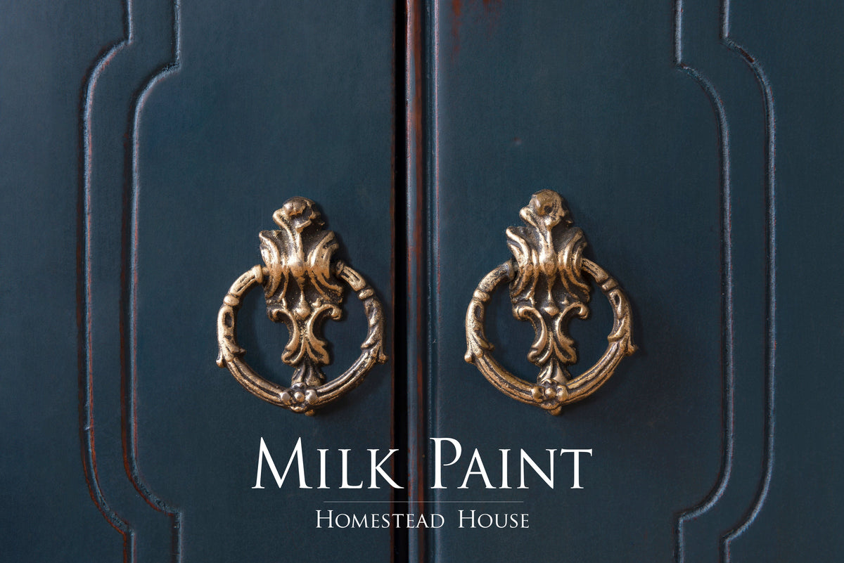 Brass handles on a cabinet finished in Homestead Blue Milk Paint by Homestead House; brand name visible below.
