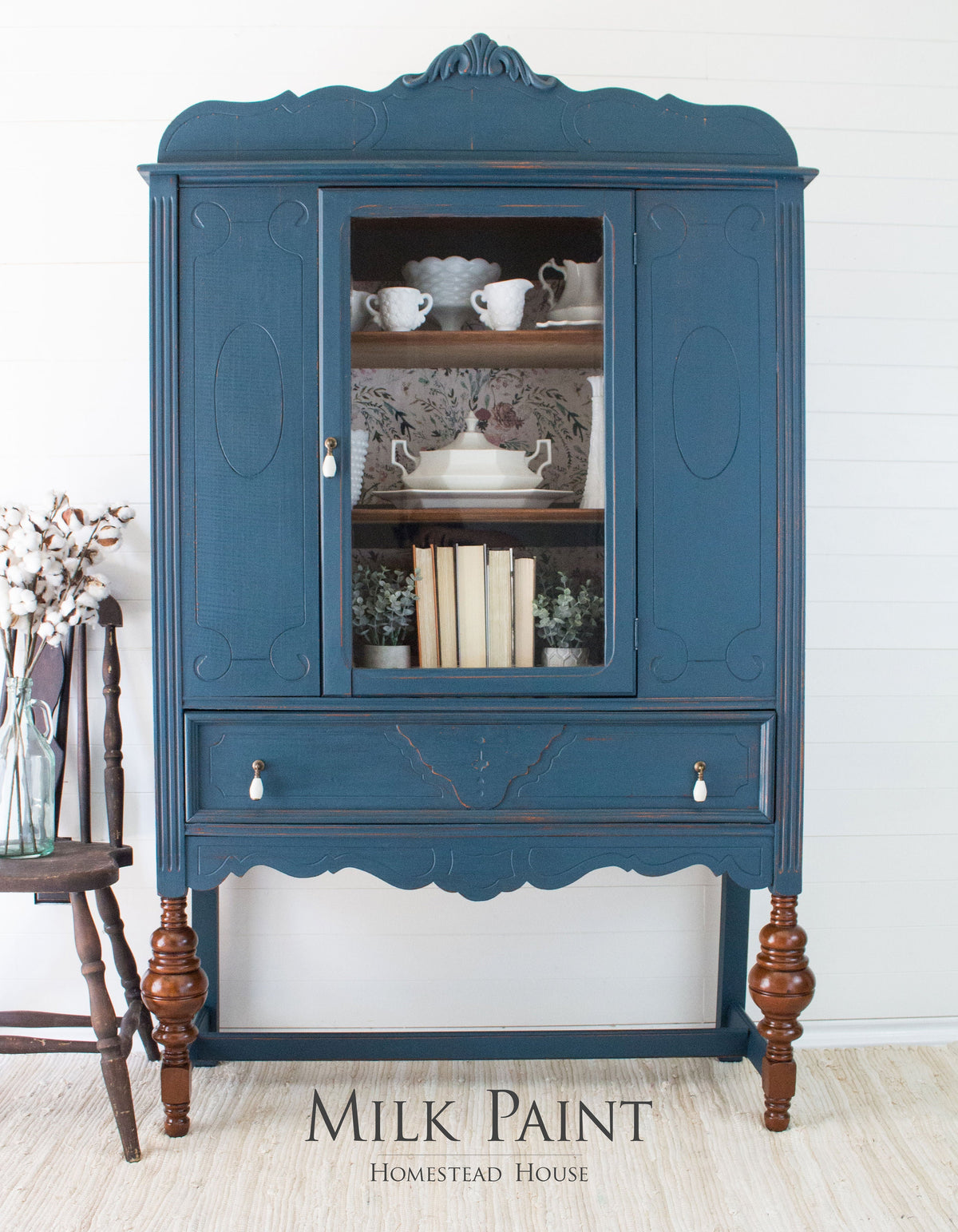 Blue vintage china cabinet with glass door, books, and teacups. Homestead Blue Milk Paint by Homestead House.