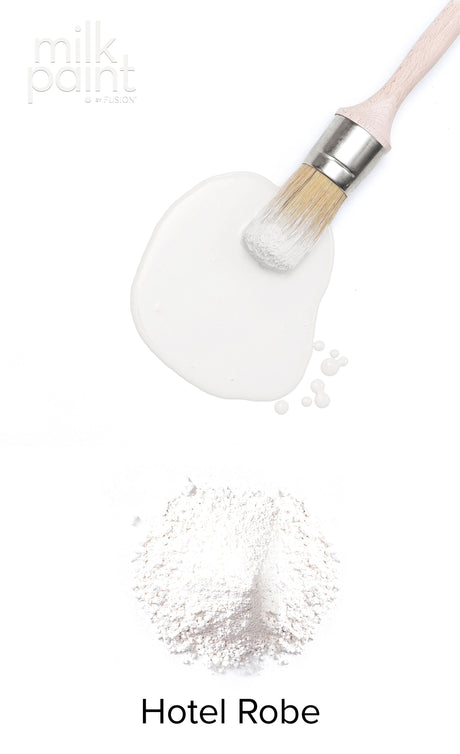 Paintbrush with Hotel Robe Milk Paint by Fusion Mineral Paint on a plain background.