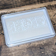 IOD Ink Pad (Uninked) by Iron Orchid Designs on a wooden surface, for use with IOD stamps.