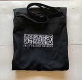 Black I.O.D. apron with ornate white lettering by Iron Orchid Designs on a light background.