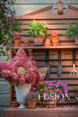 Potting bench painted in Iron Clay by Fusion Mineral Paint with potted herbs, tools, and flowers.