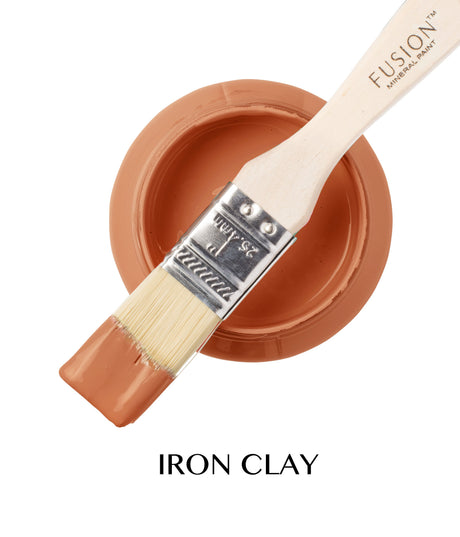 Paintbrush with terracotta paint on open jar; text below: Iron Clay Fusion Mineral Paint by Fusion.