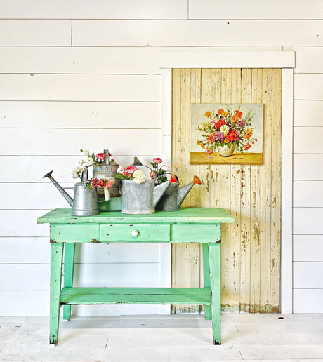 Mint-green table displayed in front of a shiplap wall and rustic door painted Julep by Old Fashioned Milk Paint.