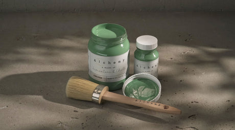 Two jars of Juniper Alchemy Paint by Fusion Mineral Paint, one open with a brush resting across the top.