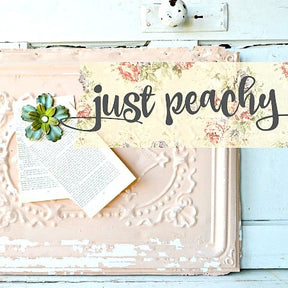 Just Peachy“ sign with floral accents, painted in Old Fashioned Milk Paint, plus paper flower and book.