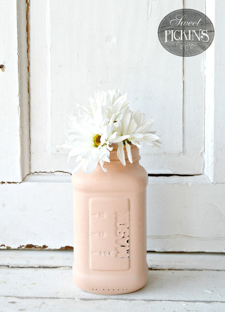 White daisies in a Just Peachy by Old Fashioned Milk Paint jar.