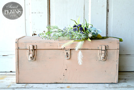Trunk painted Just Peachy by Old Fashioned Milk Paint, with flowers arranged on top.
