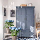 Blue cabinet painted with Homestead House Kurbits Indigo Milk Paint in a tiled, sunlit room.