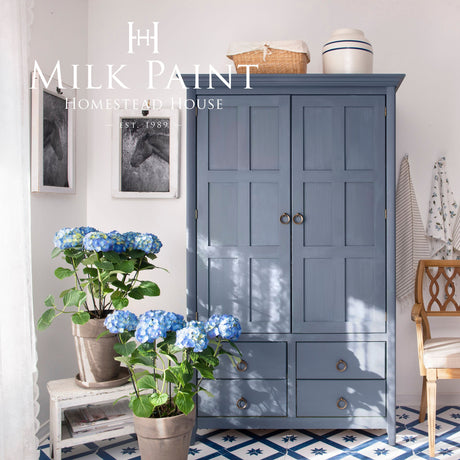 Blue cabinet painted with Homestead House Kurbits Indigo Milk Paint in a tiled, sunlit room.