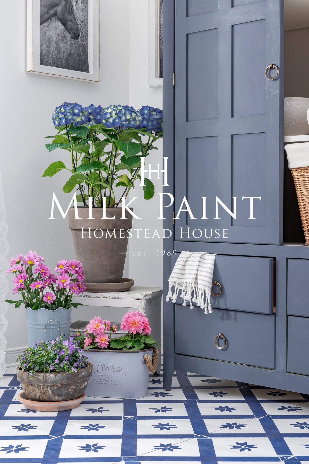Cabinet painted with Homestead House Kurbits Indigo Milk Paint beside potted flowers and a white towel.