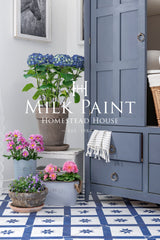 Cabinet painted with Homestead House Kurbits Indigo Milk Paint beside potted flowers and a white towel.
