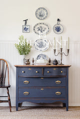 Navy dresser in Kurbits Indigo Milk Paint by Homestead House with brass handles and silver decor.