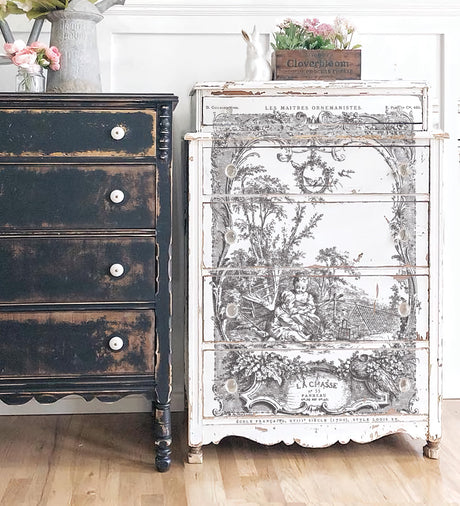 Black distressed dresser and white dresser with I.O.D. La Chasse Paint Inlay pastoral scene, both with decor items.