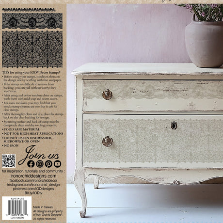 White distressed dresser decorated with I.O.D. Lace Stamp by Iron Orchid Designs, stone vase on left side.