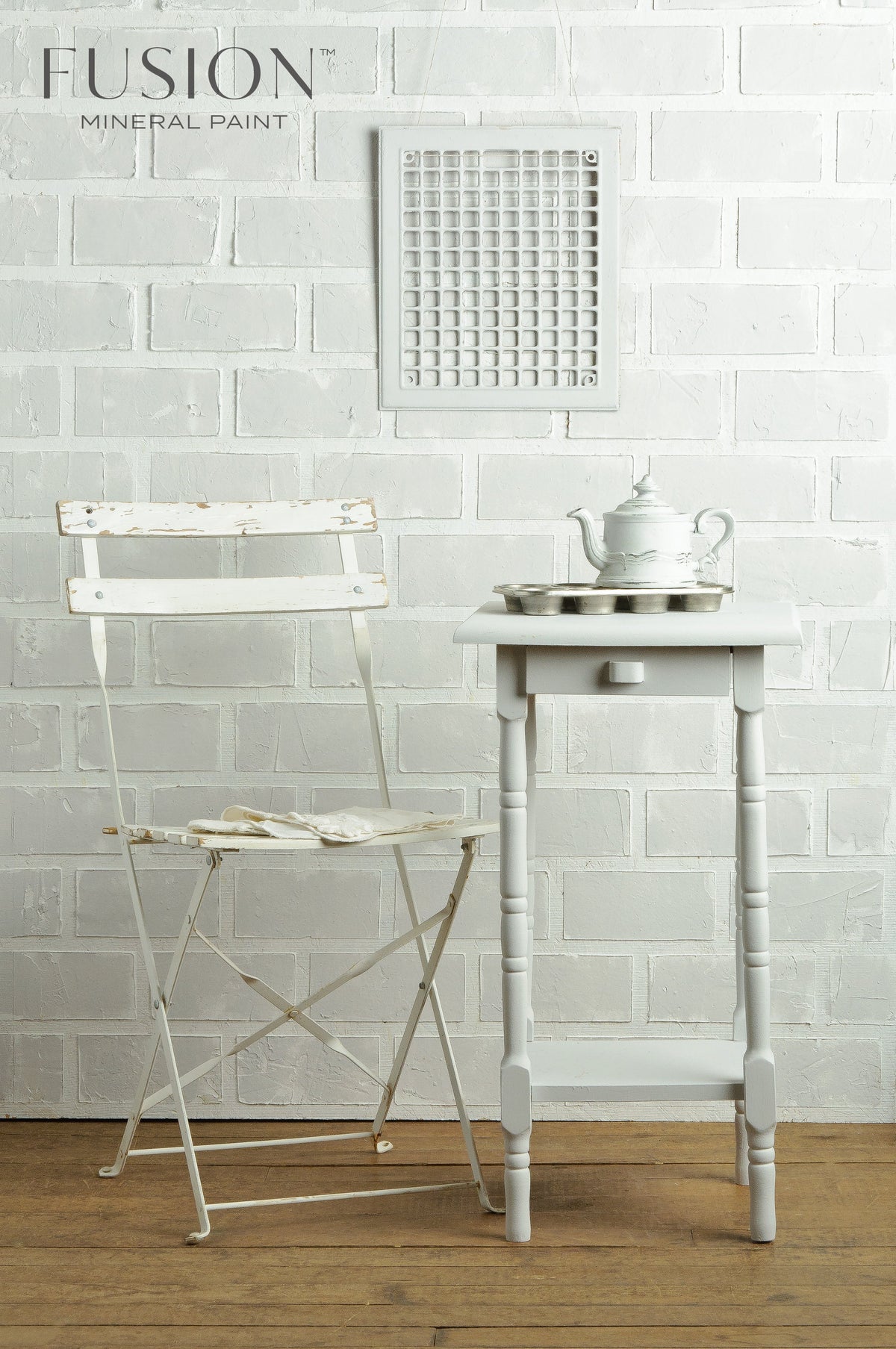 White chair, table, and teapot displayed beside a Fusion Mineral Paint Lamp White acrylic paint sign.