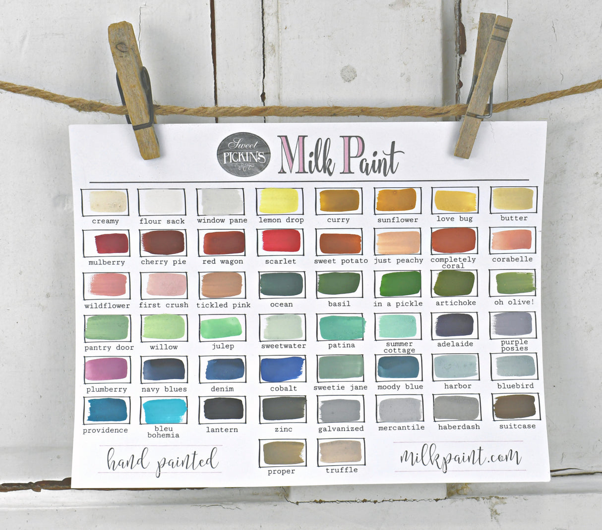 36 Lantern swatches from Old Fashioned Milk Paint, VOC free, clipped to a string with clothespins on paper.