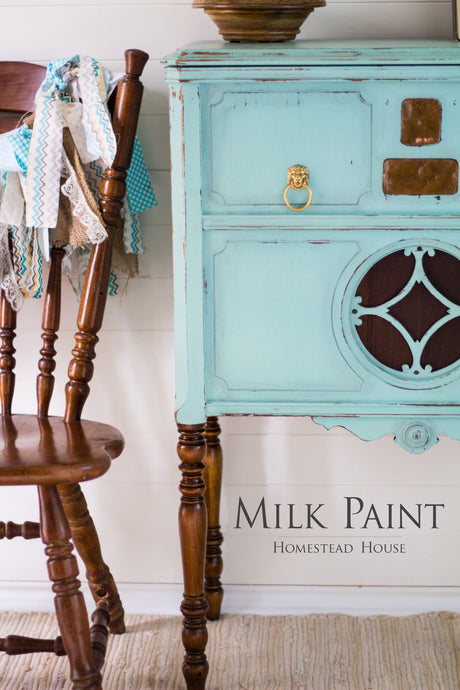 Antique wood chair beside blue Laurentien Milk Paint sideboard by Homestead House.