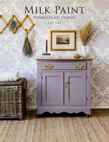 Cabinet painted in Homestead House Lavande Milk Paint, styled with decor and a wicker basket.