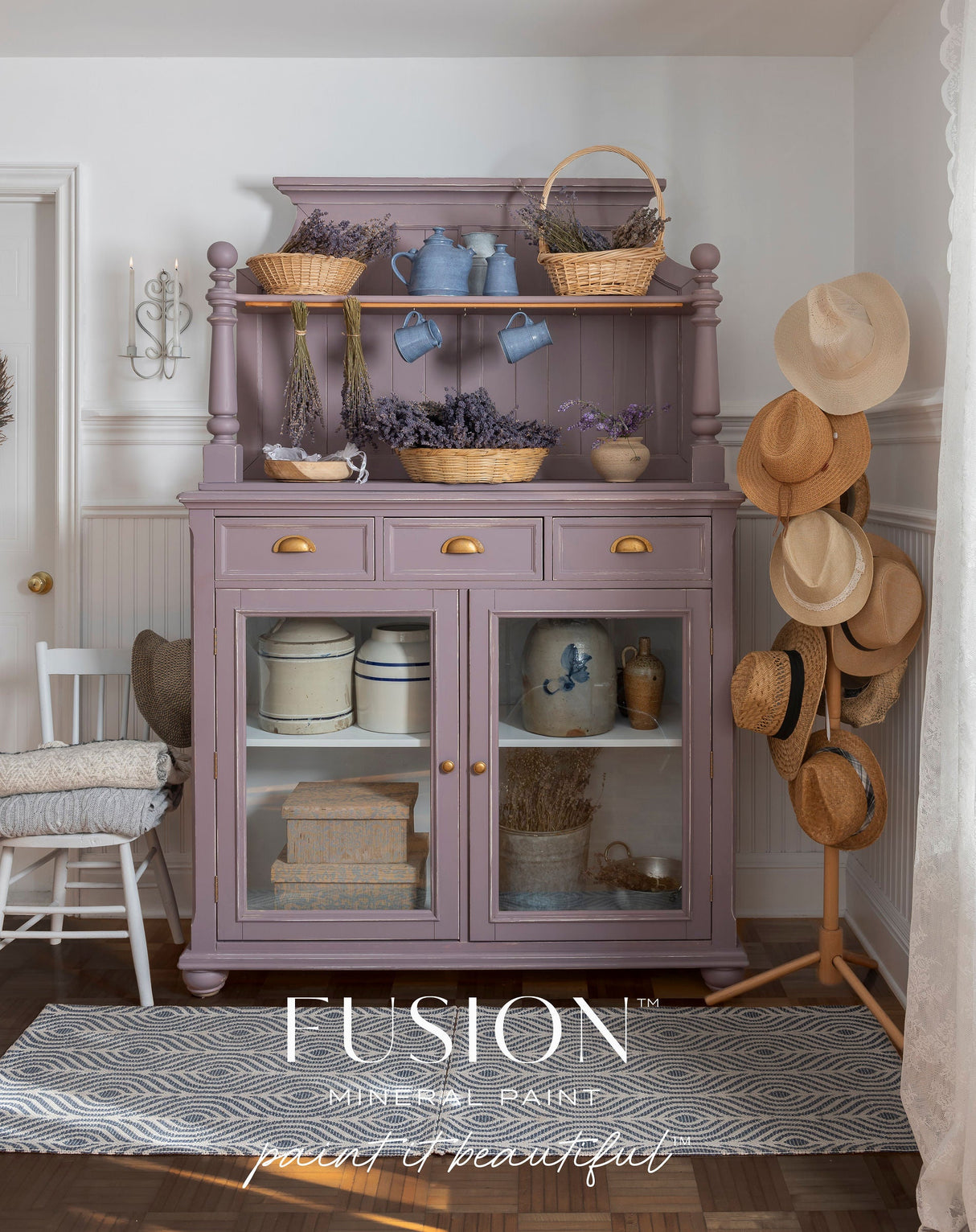 Hutch in Lavender Haze by Fusion Mineral Paint, styled with baskets, books, dried lavender, and hats on a stand.