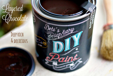Open can of DIY Paint Co. Layered Chocolate clay and chalk-based paint with brush and lid nearby.