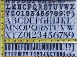 IOD Letterpress Stamp set with metallic letters, numbers, and yellow tapes from I.O.D., shown for DIY stamping projects.