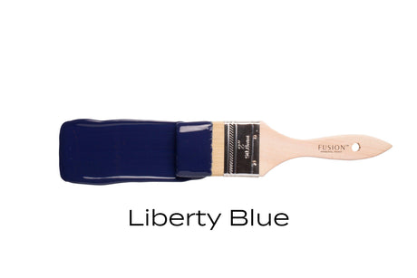 Paintbrush with Liberty Blue Fusion Mineral Paint by Fusion Mineral Paint on a plain background.