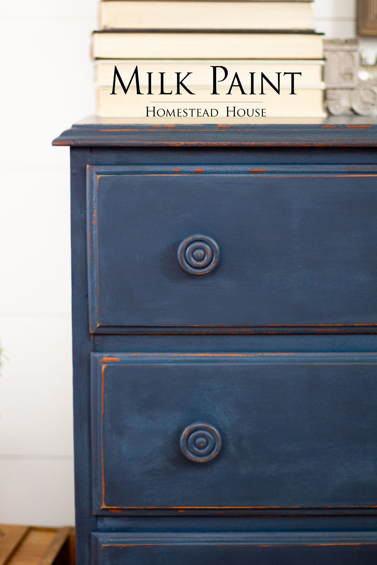 Blue dresser painted in Liberty Blue Milk Paint by Homestead House, shown with books arranged on top.